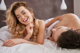 Two people smiling in bed
